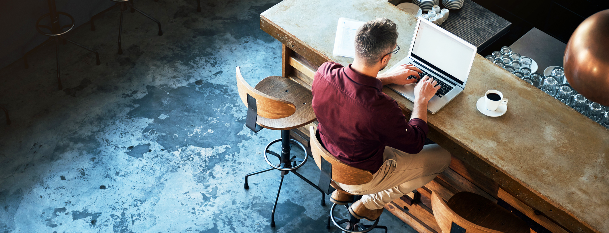 MAN WORKING AT WOOD DESK