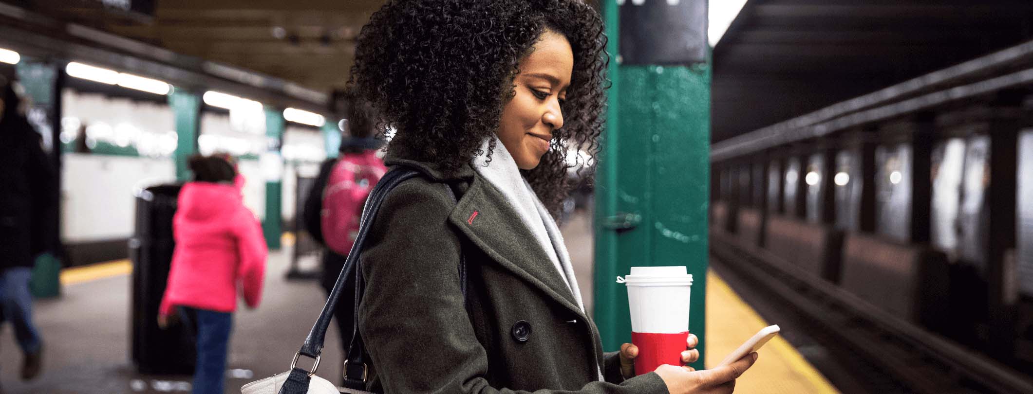 woman on her phone at a subway station