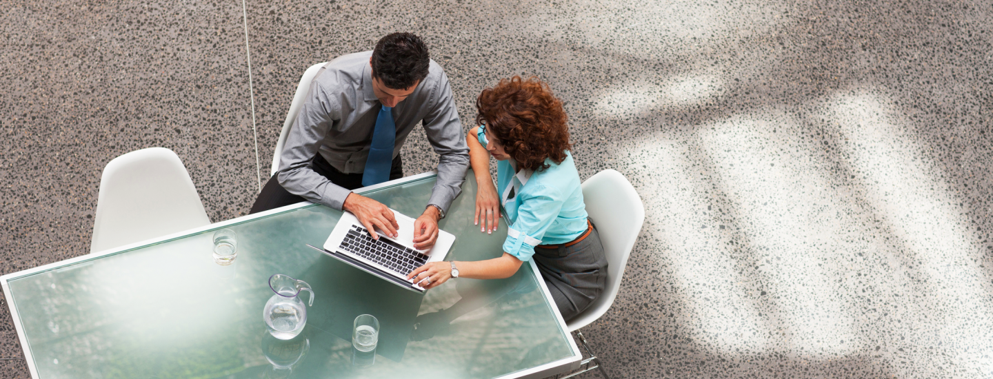 couple looking at laptop on outside patio table