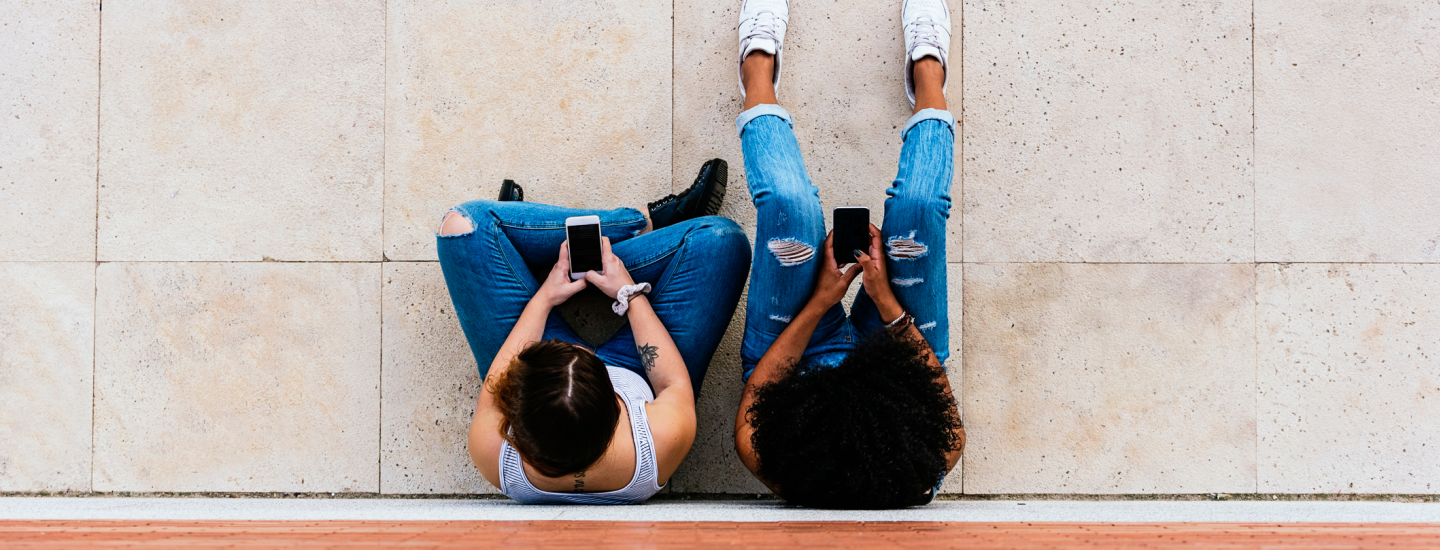 looking down on two people staring at mobile phones