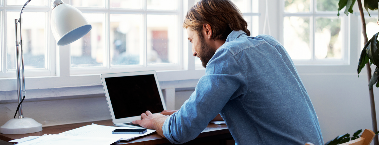 man in office looking at laptop computer