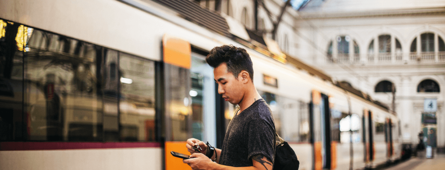 Man checks phone at train station