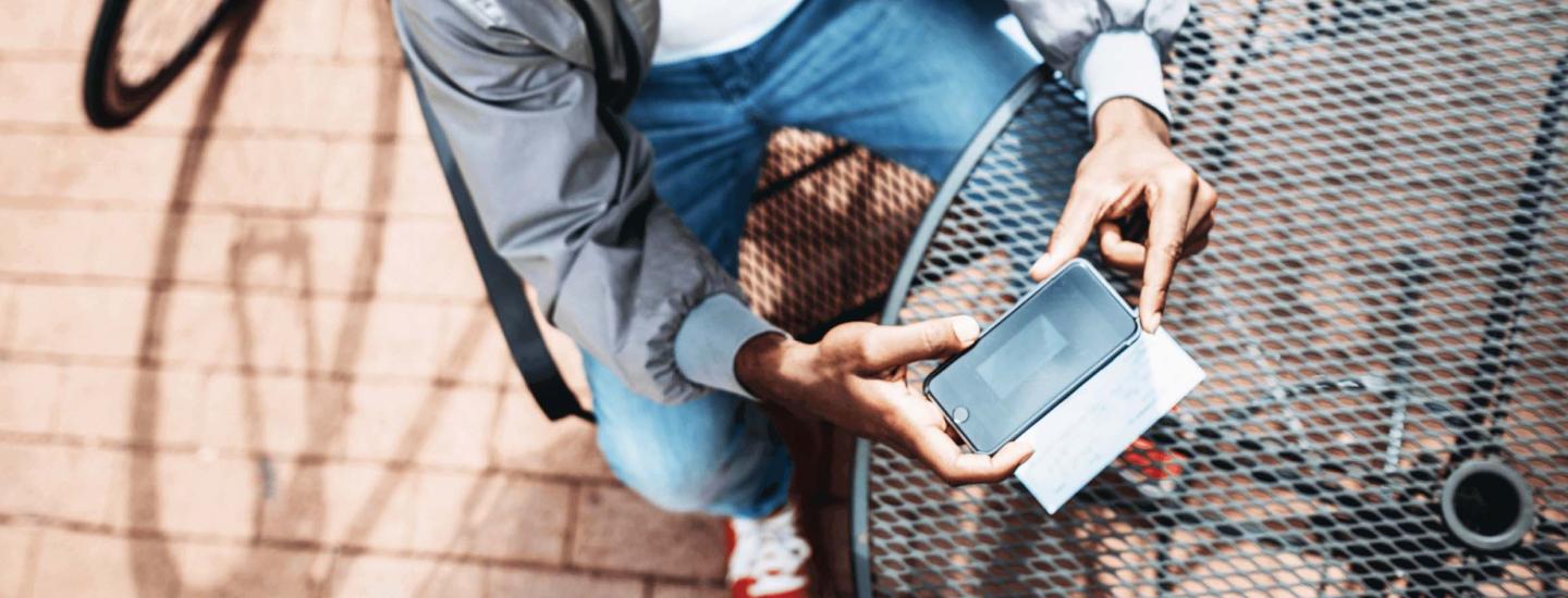 Birds eye view of man taking photo of check with phone