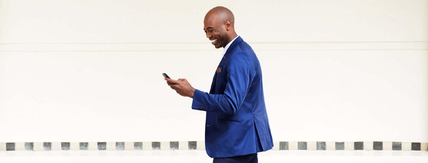 man in suit laughing at mobile phone