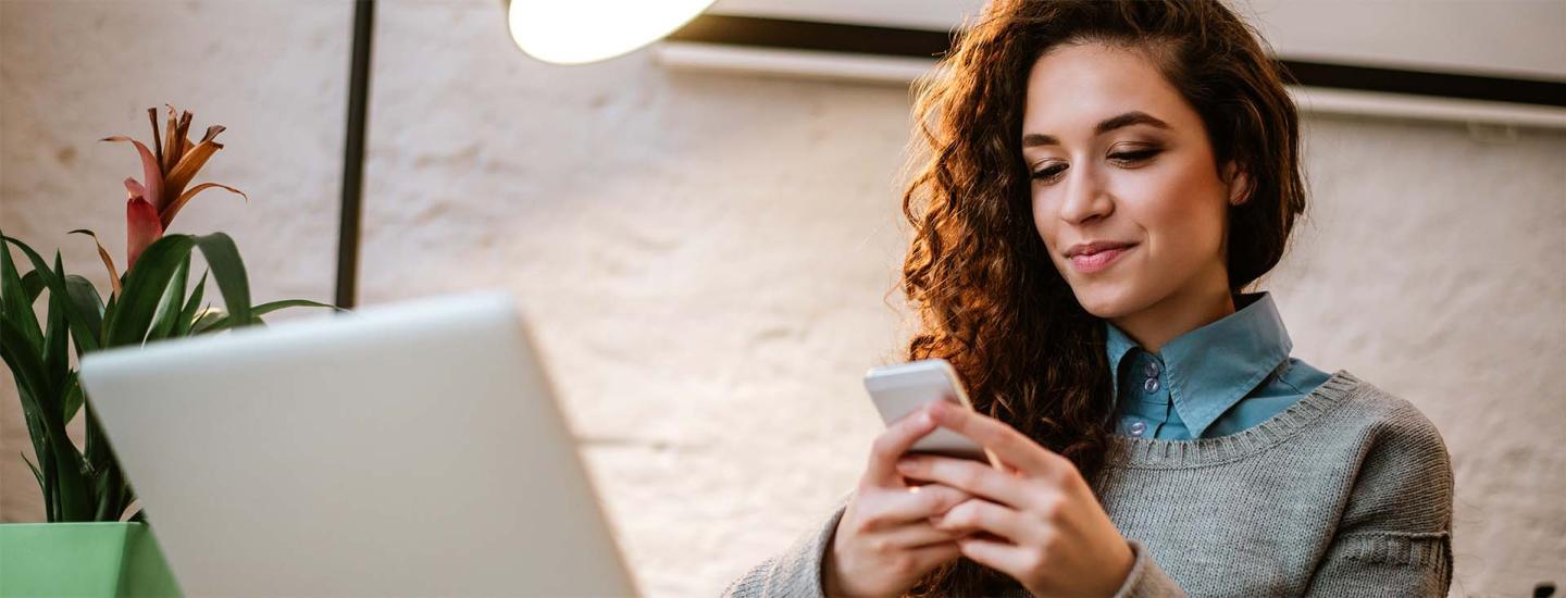 woman on her phone and laptop