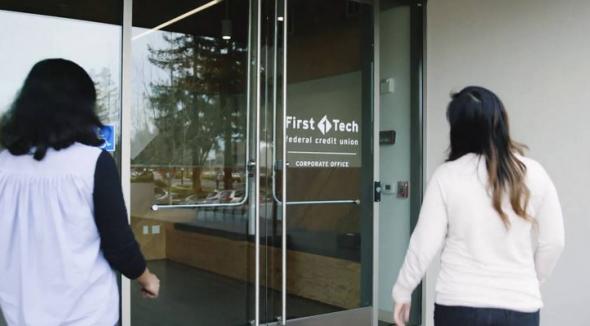 two females walking into a first tech bank